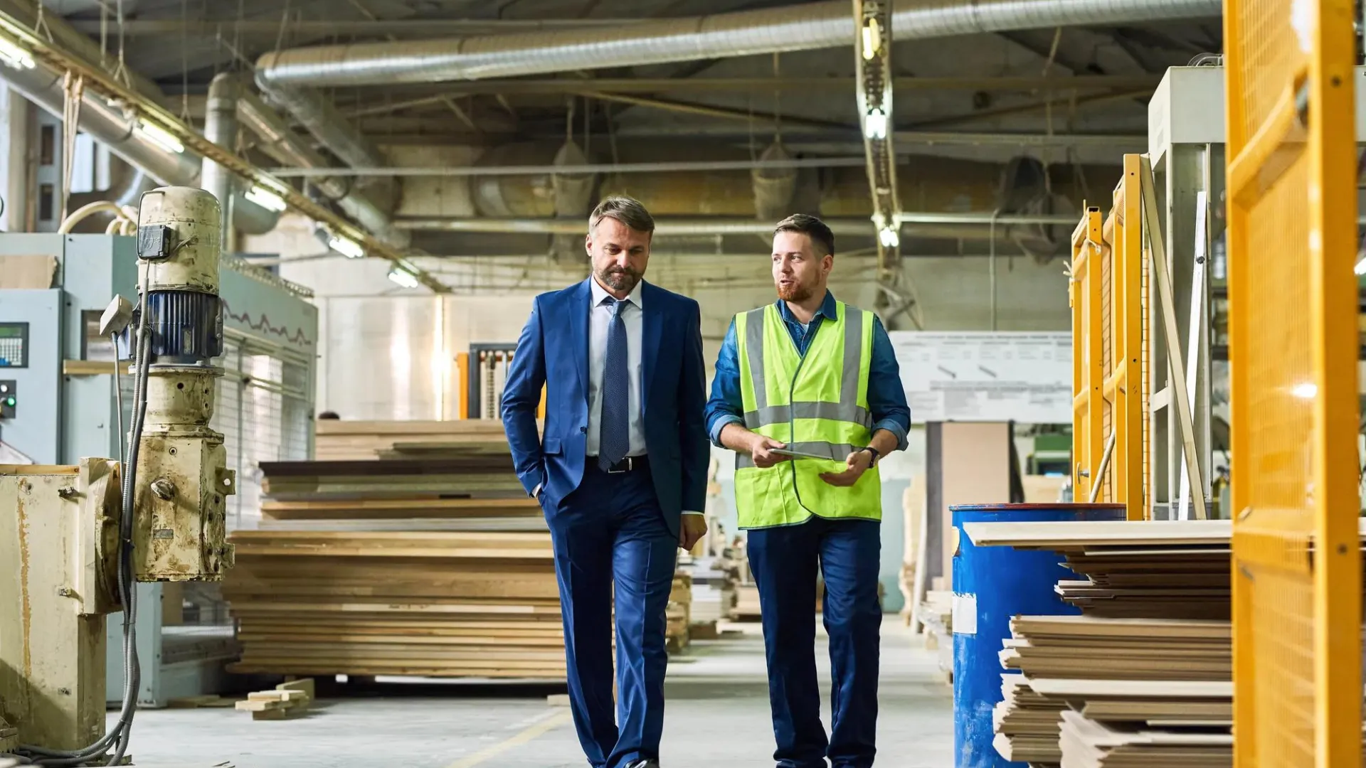 A businessmen and a construction worker walking and discussing the project they are working on