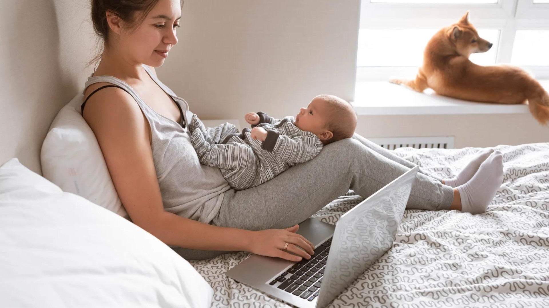 A mother sitting on the bed with her child in her lap