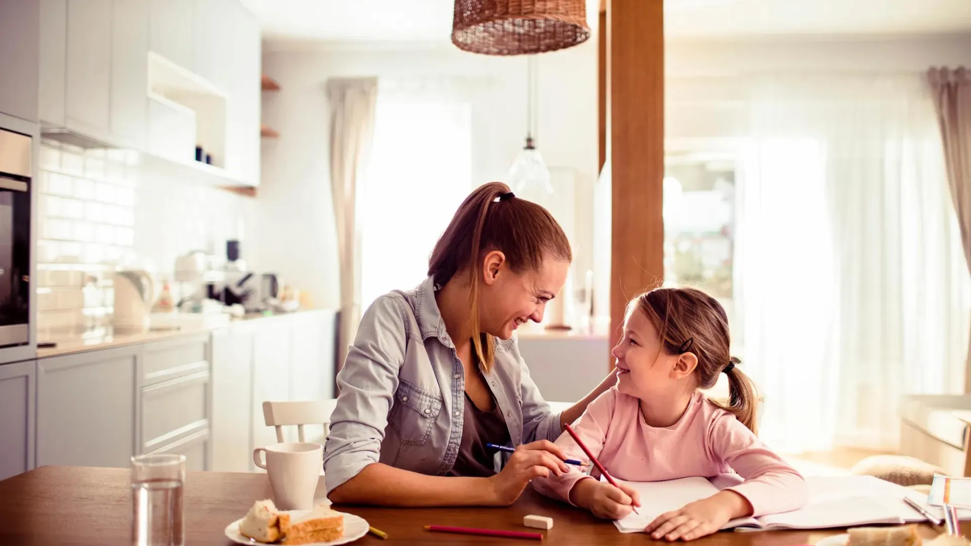 Mom and daughter at kitchen table reviewing homework
