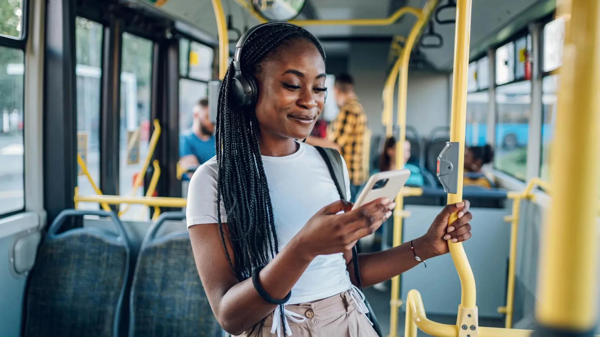 Young woman on city bus looking on her phone