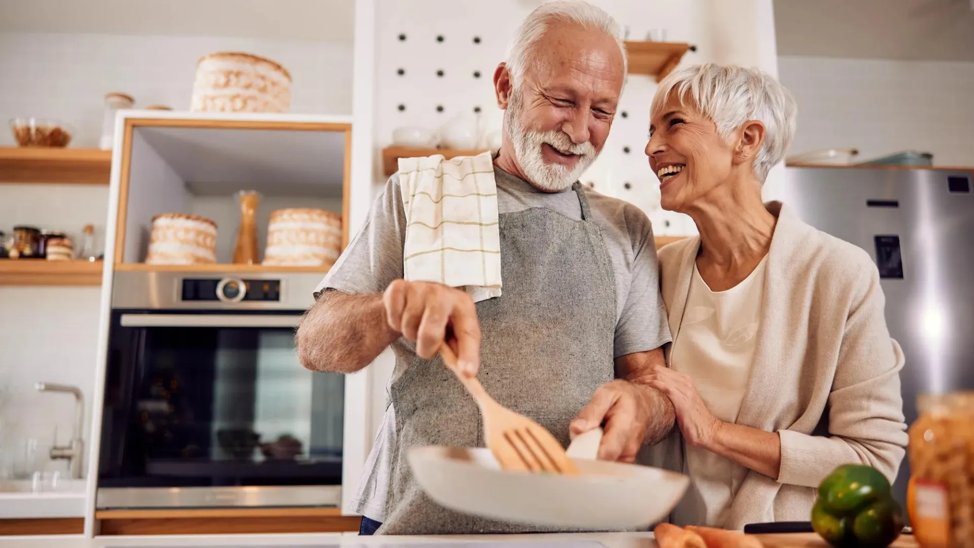 Older man and woman in kitchen making a meal