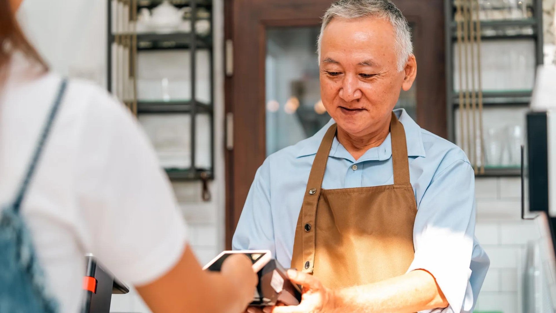A cashier for a small business receives a digital payment from a customer.