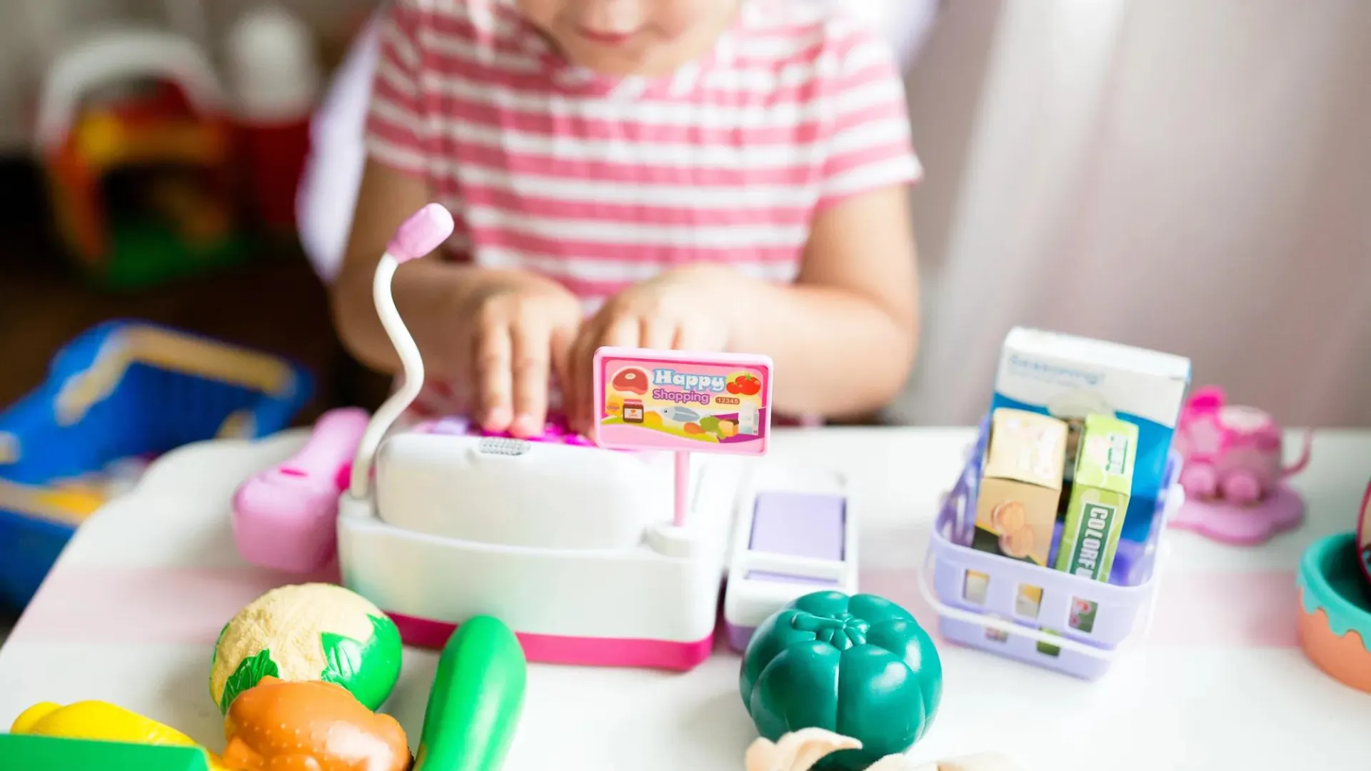 Child playing with a toy cash register
