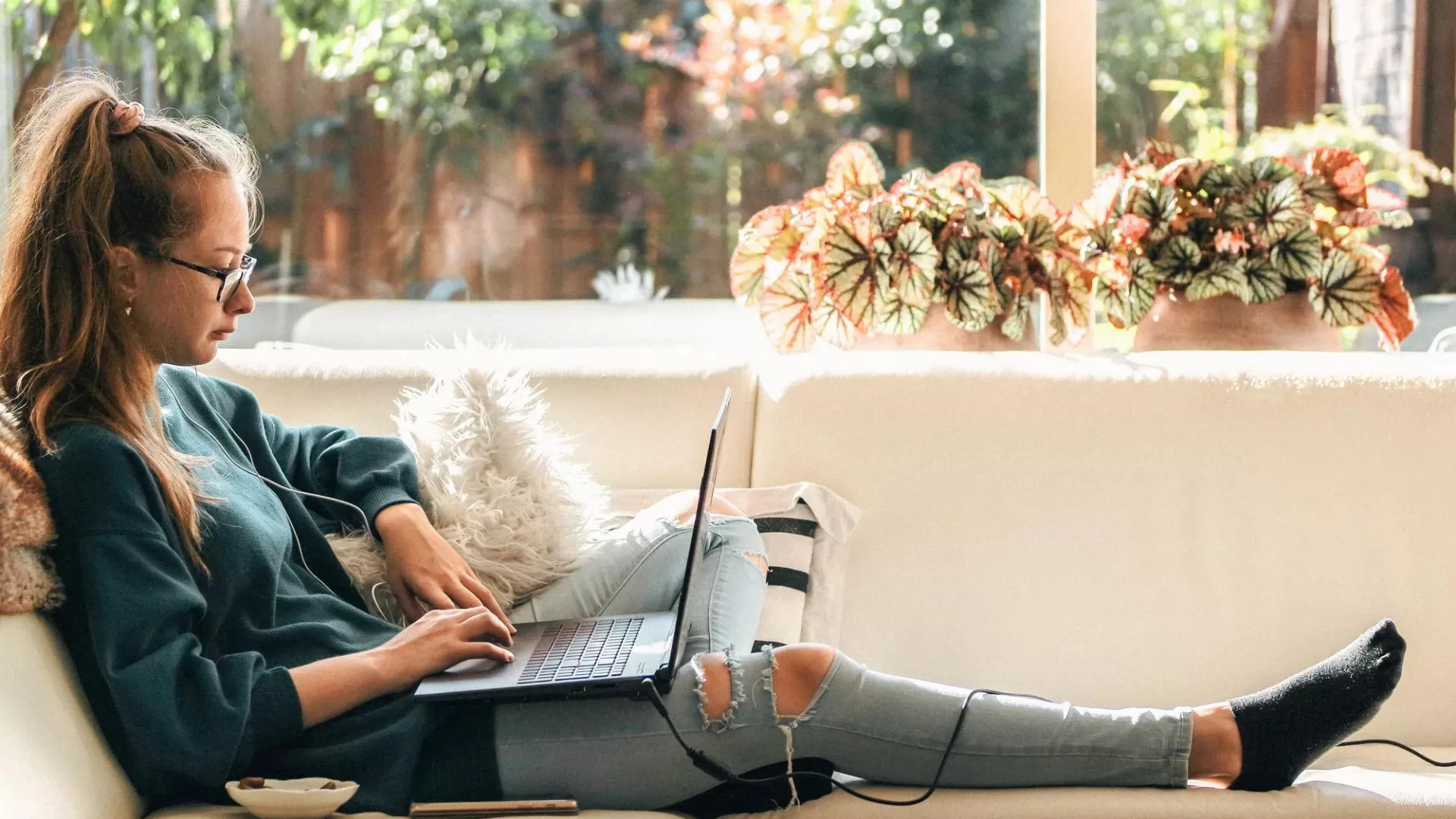 Person working on a laptop on a couch.