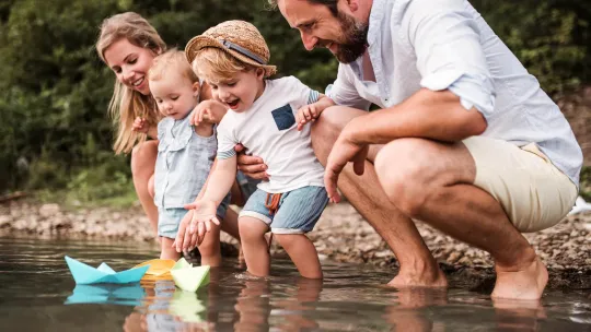 Parents and two toddlers playing in water.