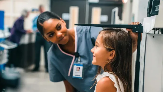Nurse measuring height of girl