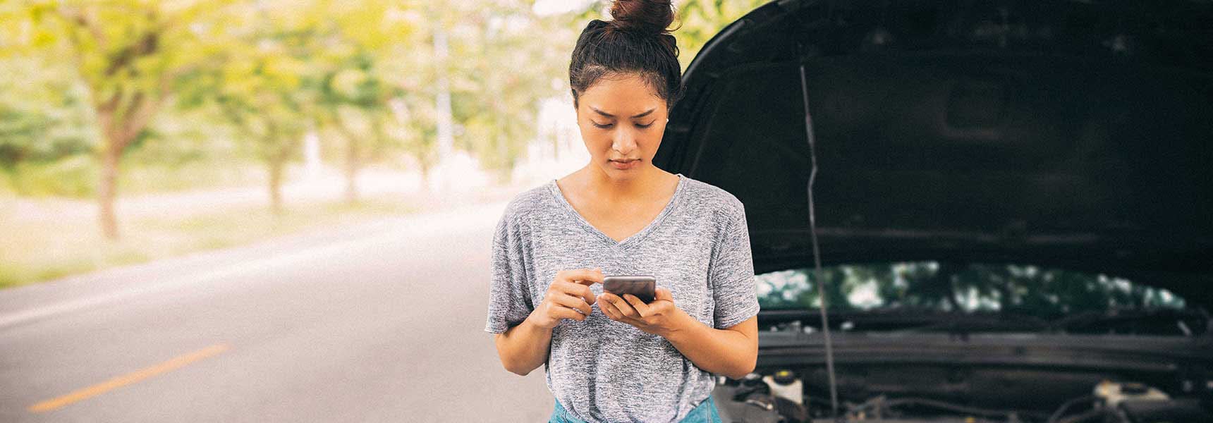 Photo of a woman with a broken down car.