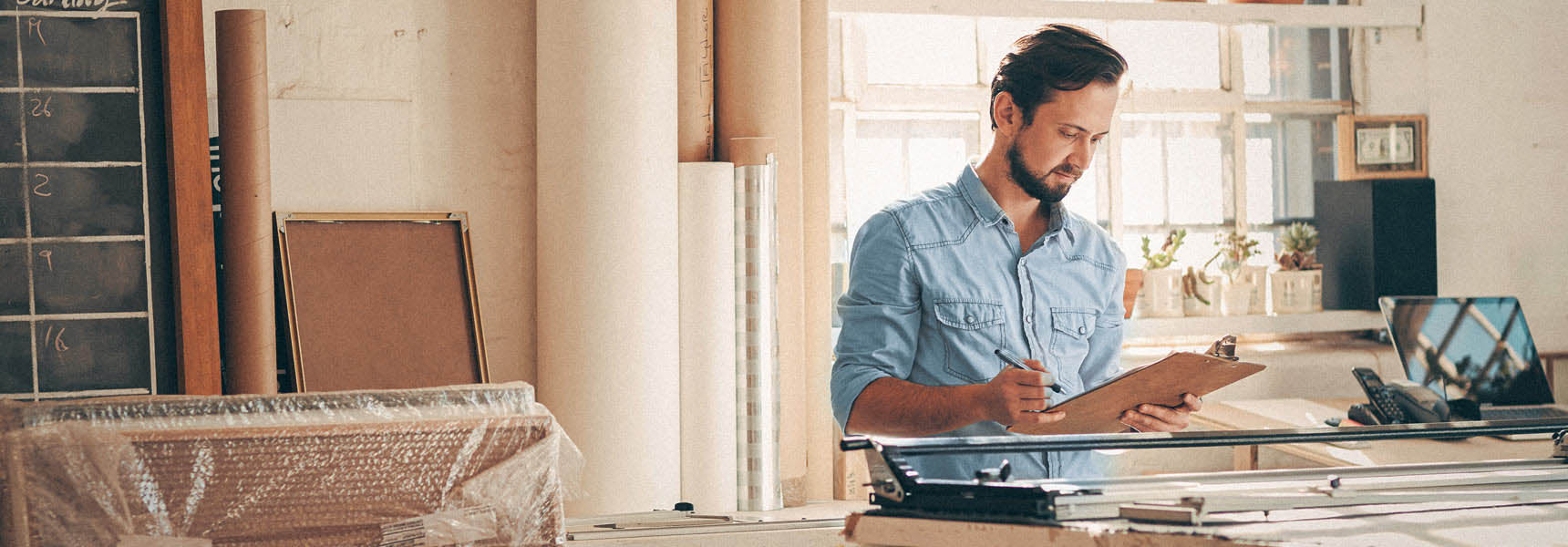 Image of a man writing on a clipboard. Photo of a man writing on a clipboard.