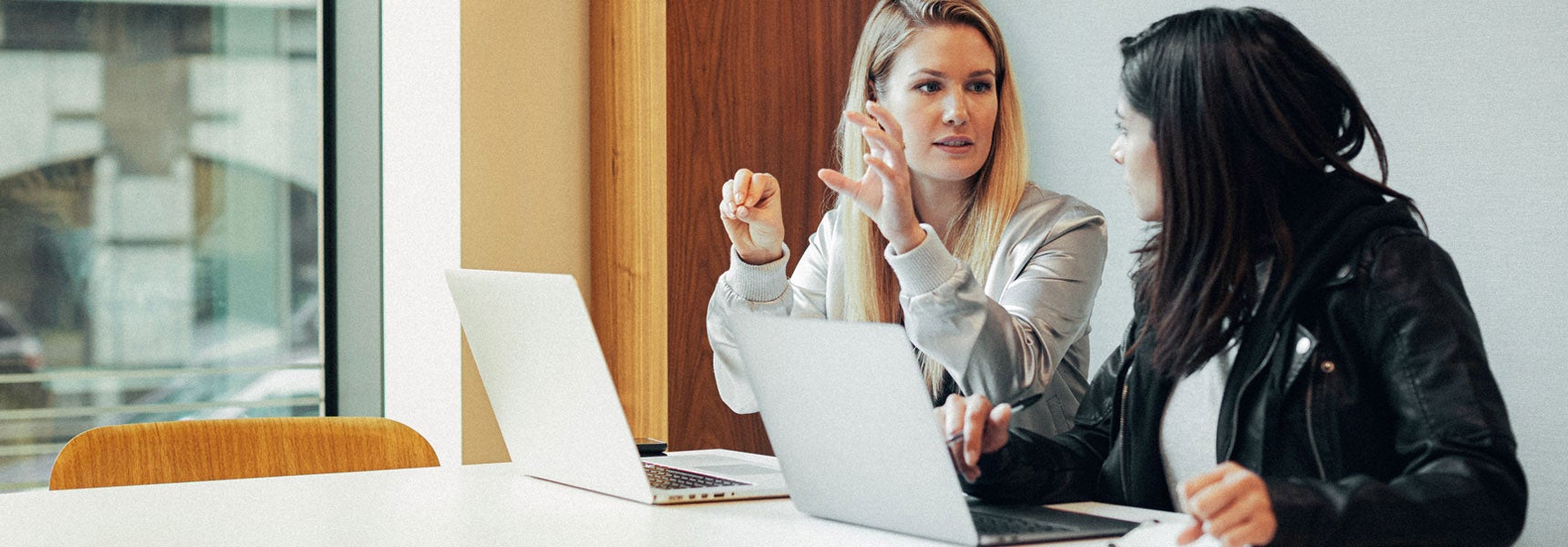 Photo of two women reviewing something on a computer.
