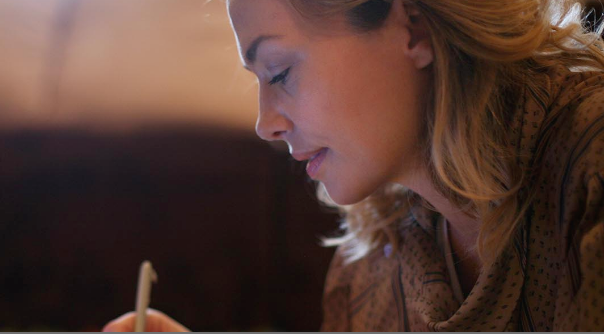 Photo of a woman writing in a notebook.