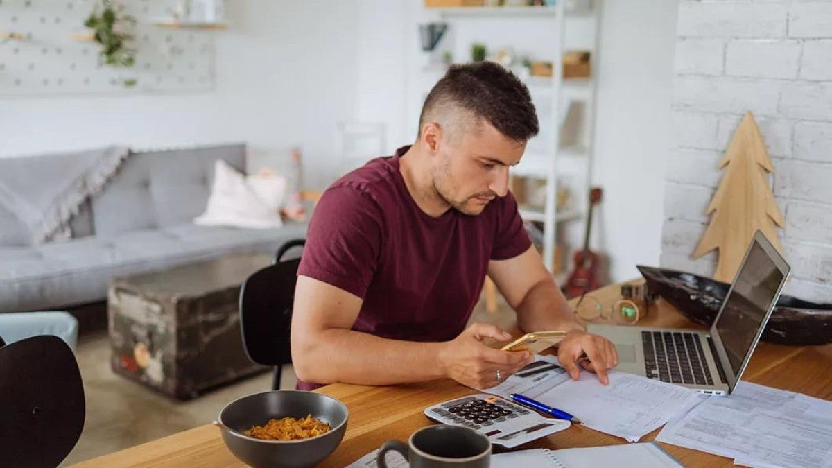 Photo of a man researching different methods to pay off debt.