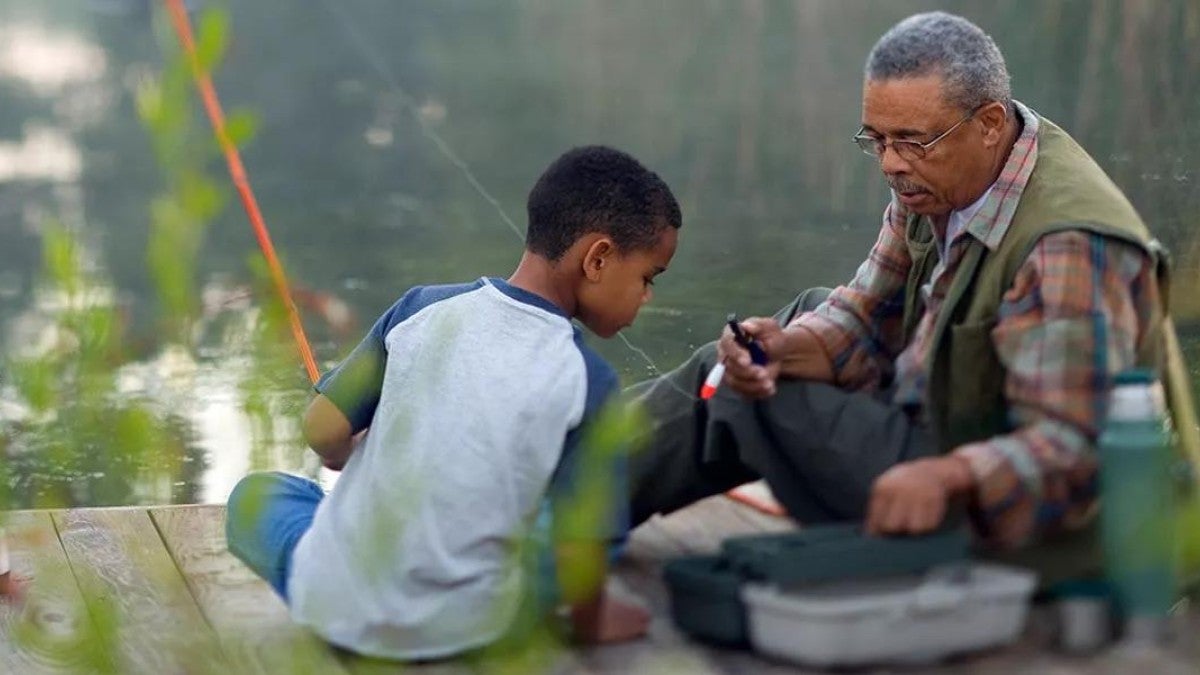 Grandfather thinking about his retirement while fishing with grandson.