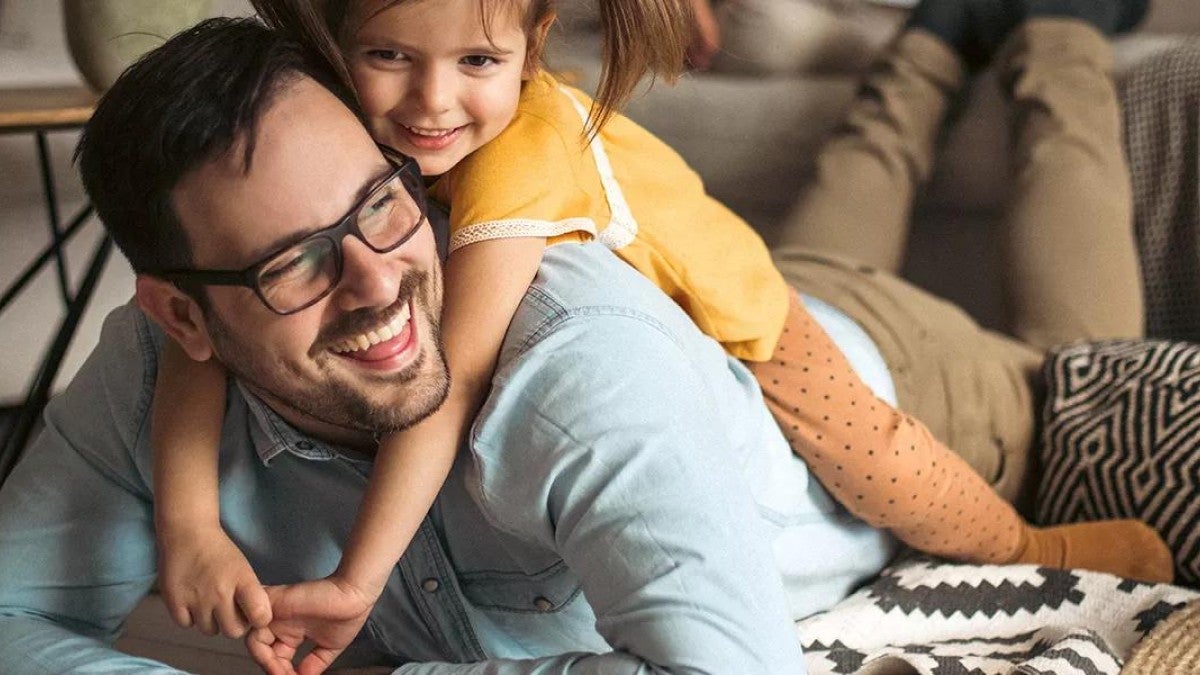 A dad playing with his daughter.