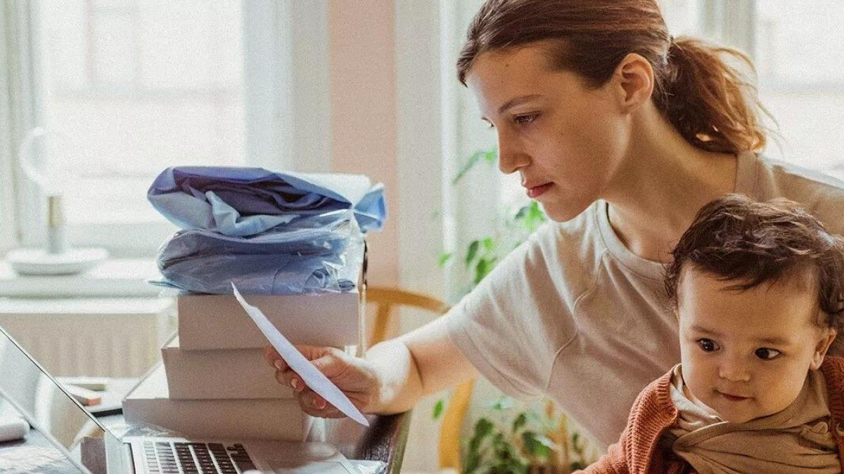 Businesswoman reading document while sitting with baby