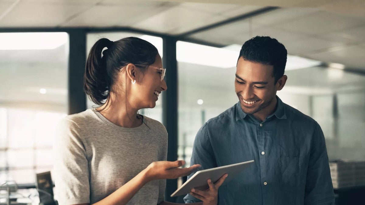 Shot of two young workers using a digital tablet in a modern office.