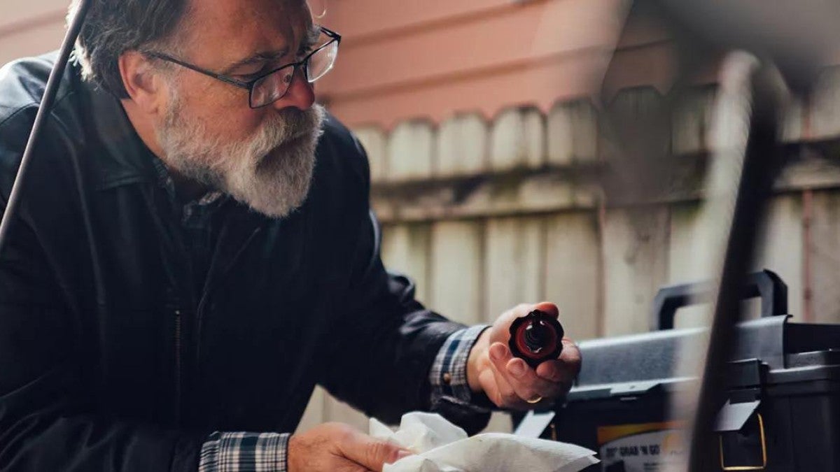 Man who performs regular checkups on his vehicle much like on his retirement plan to determine if his goals are still on track.
