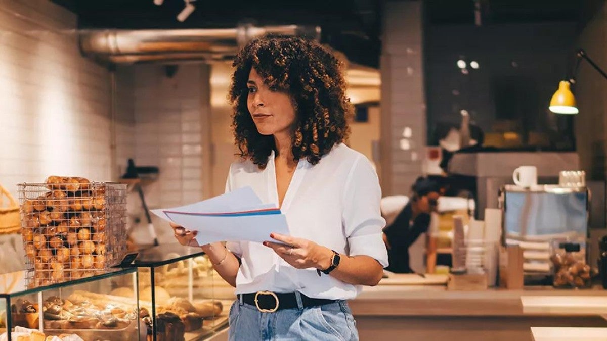 Businesswoman looking at a handful of papers.