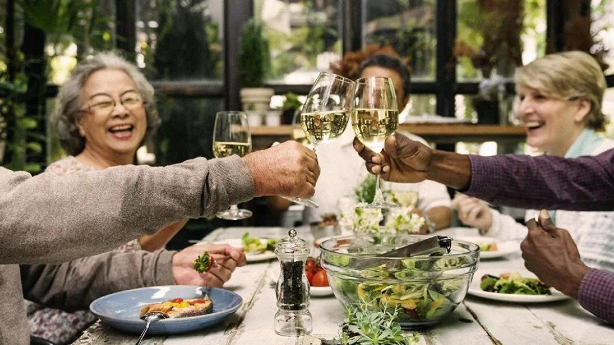 Photo of friends enjoying a meal together around a table.