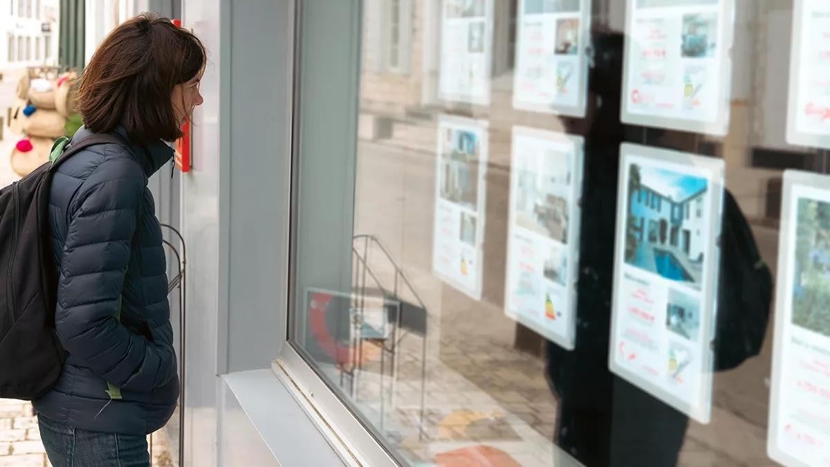 woman in front of the window of a real estate agency