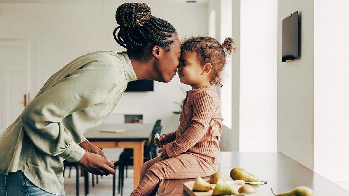 Picture of a mother and her young child playfully touching their noses together.