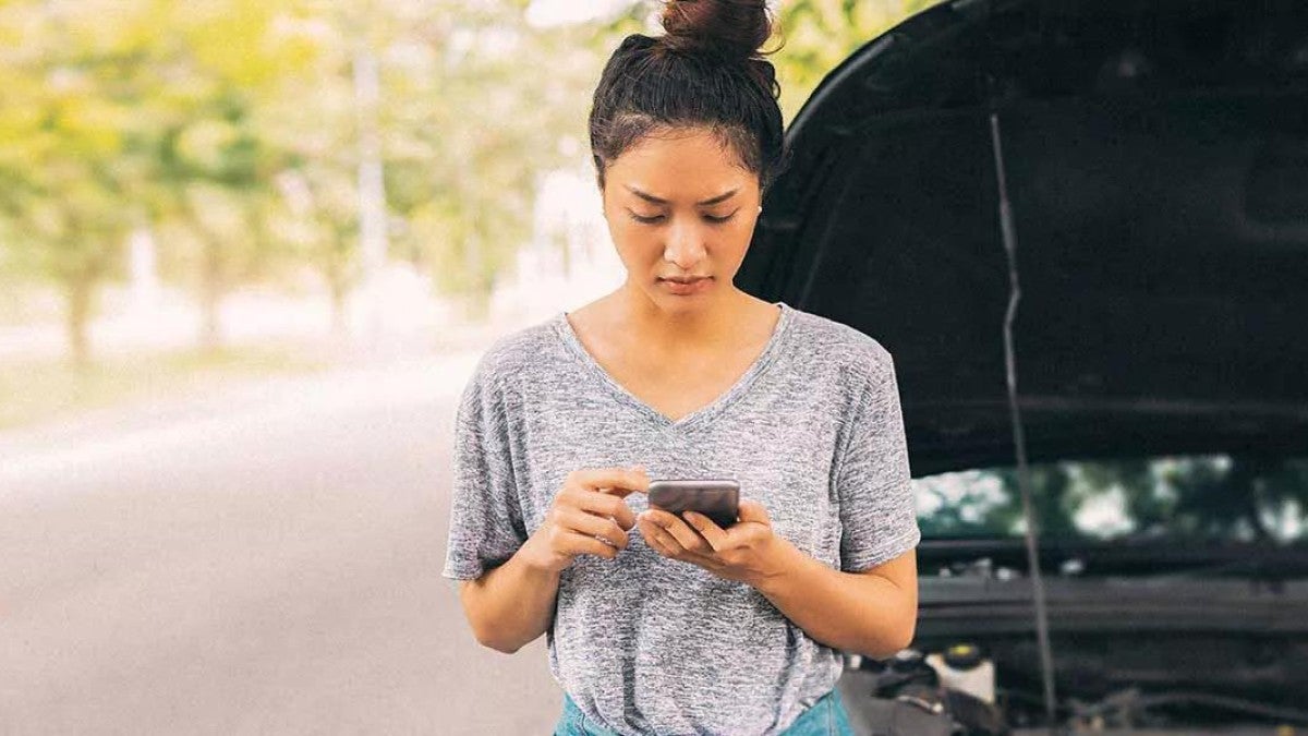 Photo of a woman with a broken down car.