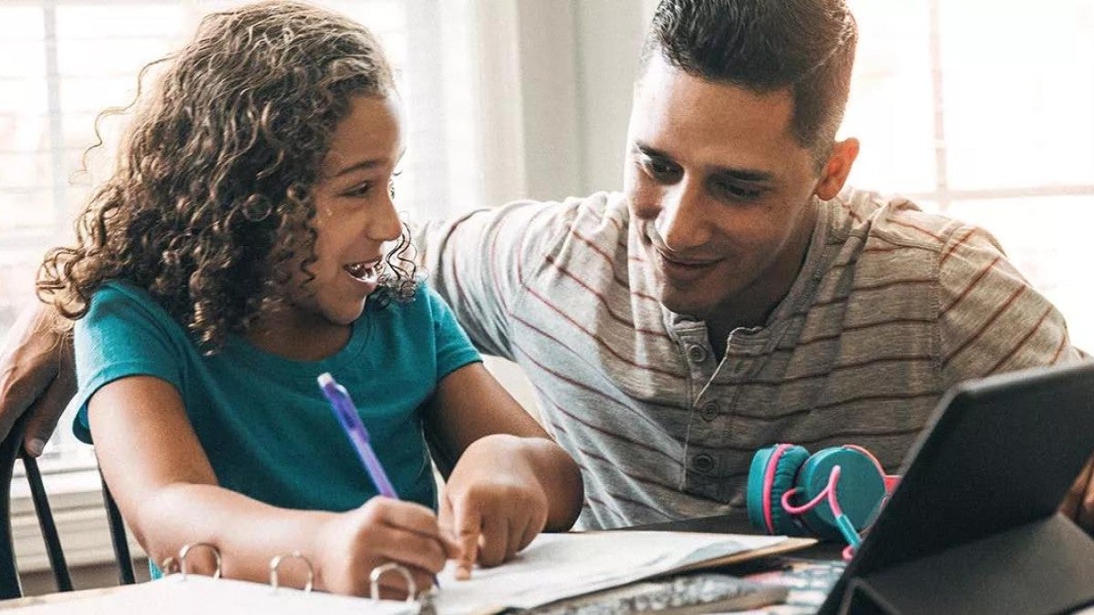 Photo of a man and child reviewing ways to save for college on a computer.