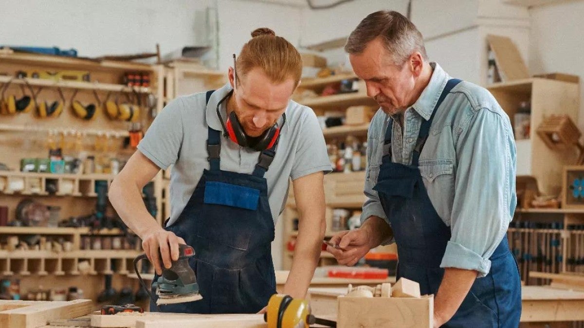 Photo of two men working on a small woodworking business.