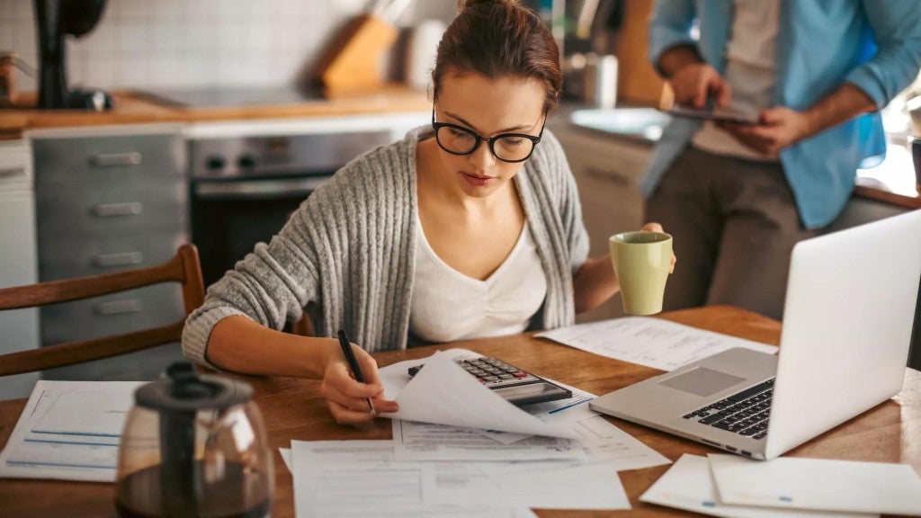 Woman sitting at table with computer working on a budget