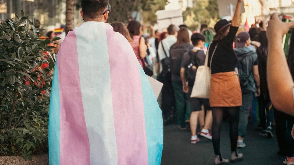 People at a Pride parade with transgender rights flag