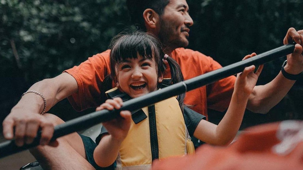 A father is canoeing with his young daughter.
