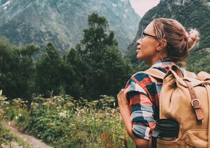 Person hiking on a trail through the mountains.