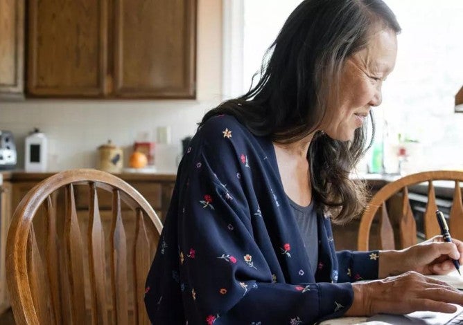 Woman working from home at laptop in kitchen