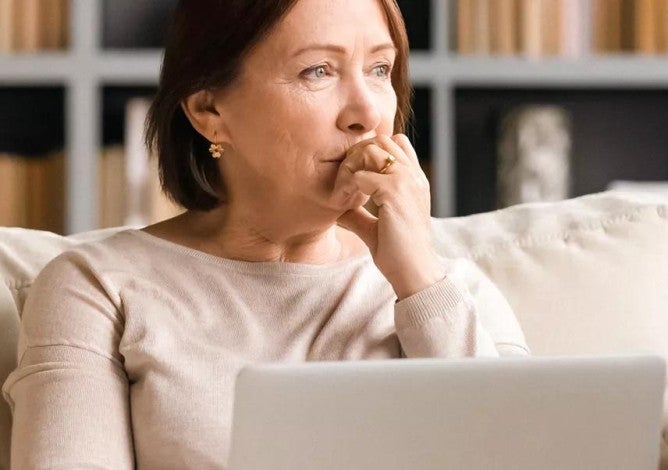 Person sitting on couch pondering their finances