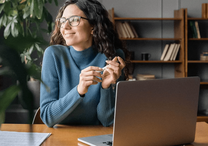 Woman at a desk enjoying the sunlight for her window.