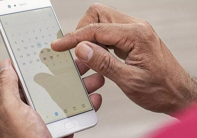 Una persona revisando su calendario en su teléfono