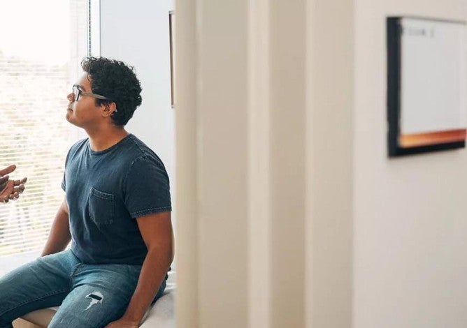 A doctor talking to a patient in an exam room.