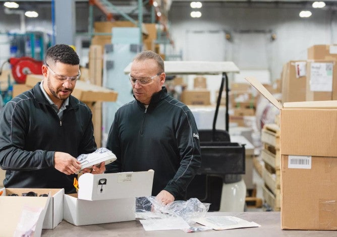 Two employee-owners of Baker Group collaborate in the company's workshop.