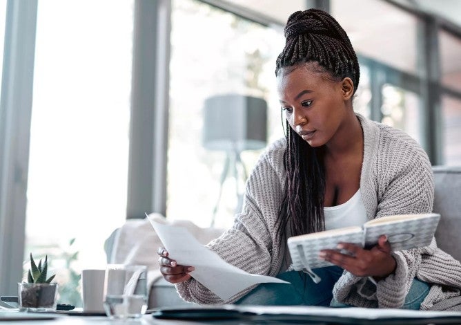 Woman sitting together on a couch working on their budget on a computer