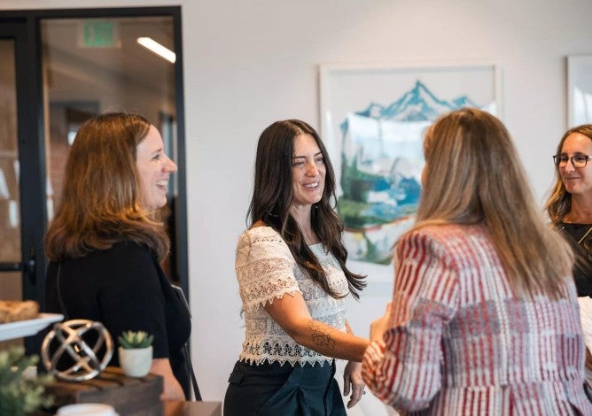 Professional women shaking hands while meeting each other in a small group