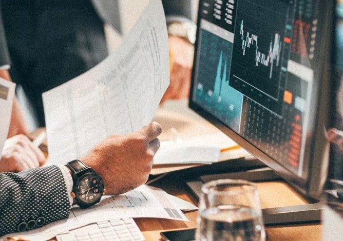 Photo of someone reviewing stock market charts.