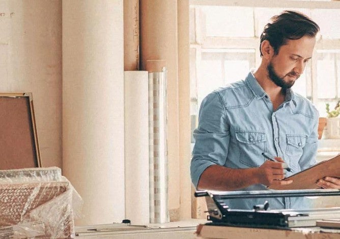 Man at work looking at a clipboard with his savings plan