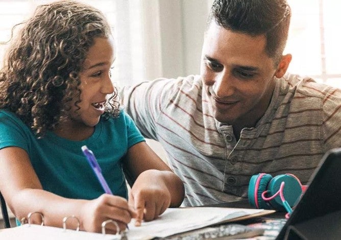 Photo of a man and child reviewing ways to save for college on a computer.