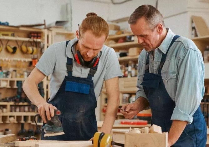 Photo of two men working on a small woodworking business.