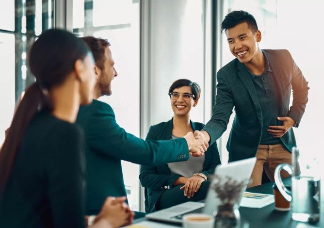 Man shaking hands with co-worker during a new job meeting