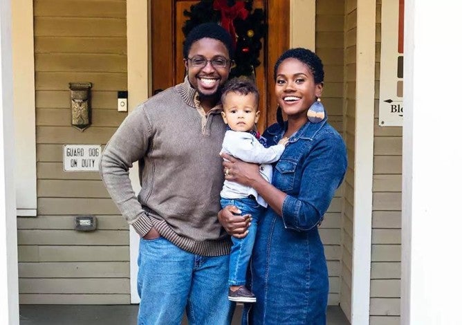 Portrait of black family and child in front of home for the holidays