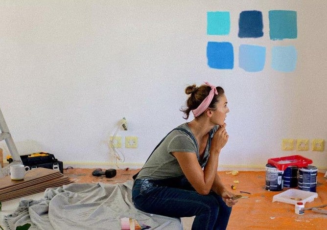 Image of a woman considering paint colors in her home.
