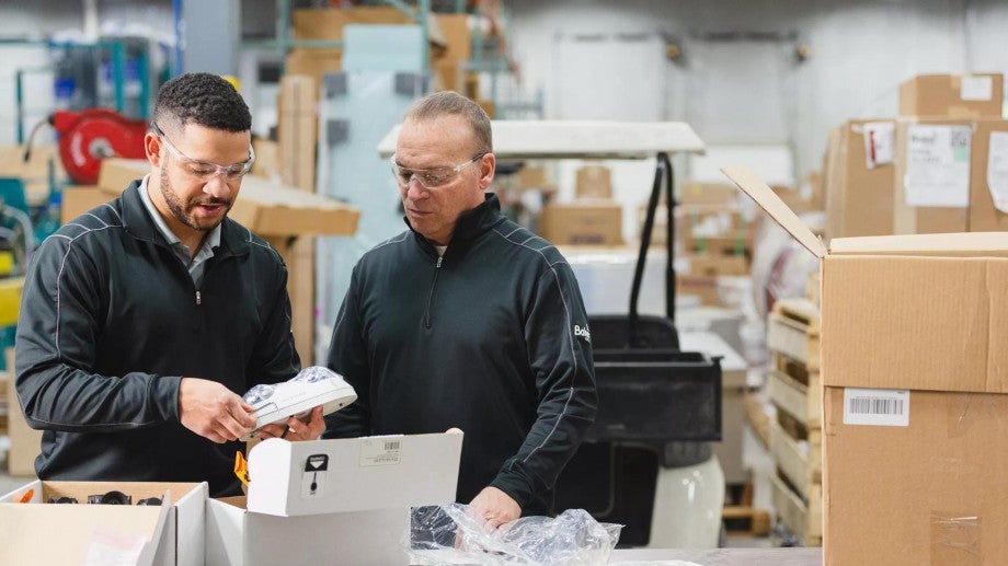 Two employee-owners of Baker Group collaborate in the company's workshop.