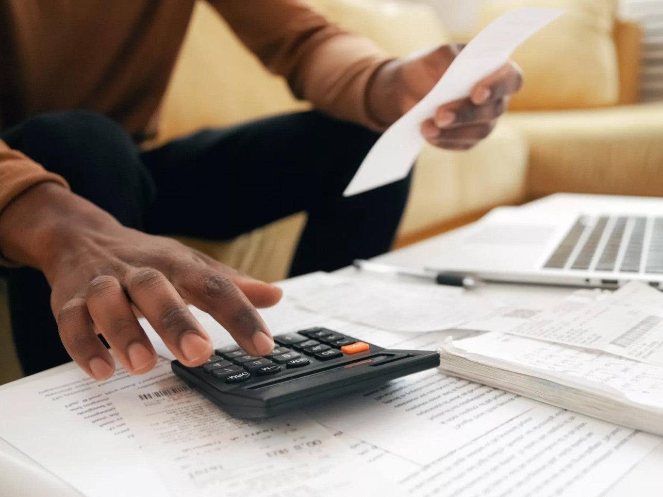 Person using calculator to determine cost. Person using calculator to determine cost.
