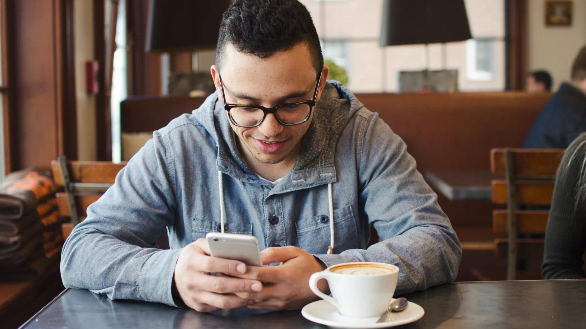 Hombre joven usando su teléfono para informarse sobre cuentas de inversión y términos de productos.