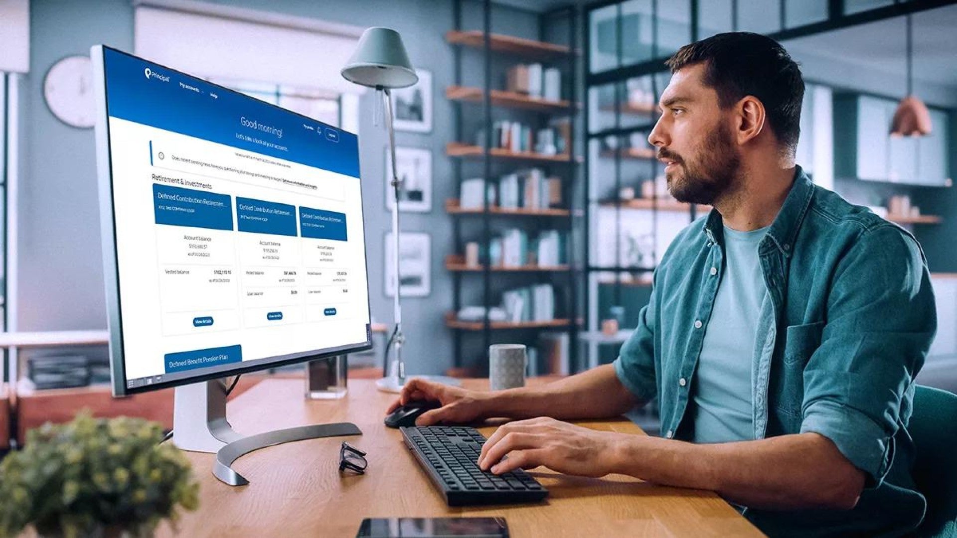 Man sitting at a desk checking his financial information on a desktop computer.